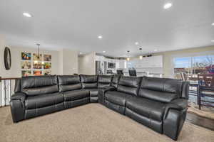 Carpeted living room with an inviting chandelier and plenty of natural light