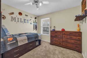 Bedroom with ceiling fan and light colored carpet