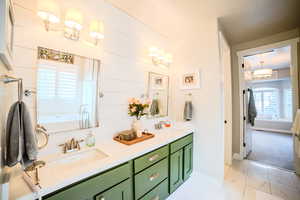 Bathroom featuring vanity, tile patterned flooring, and a bathing tub