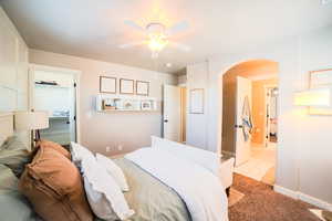 Carpeted bedroom with a walk in closet, ceiling fan, a closet, and ensuite bathroom