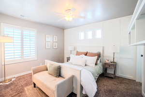 Carpeted bedroom featuring ceiling fan