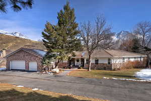 View of front of house with a mountain view, a front lawn, and a garage