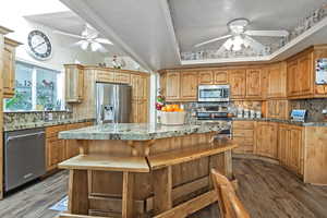 Kitchen featuring sink, tasteful backsplash, a kitchen island, dark hardwood / wood-style flooring, and stainless steel appliances