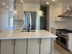 Kitchen featuring a large island with sink, white cabinetry, sink, and appliances with stainless steel finishes
