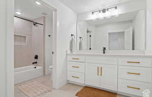 Full bathroom featuring tile patterned flooring, toilet, vanity, and tiled shower / bath