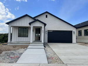 View of front of property with covered porch and a garage