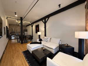 Living room featuring brick wall and wood-type flooring