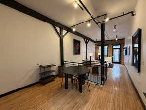 Dining area with brick wall, light wood-type flooring, and rail lighting