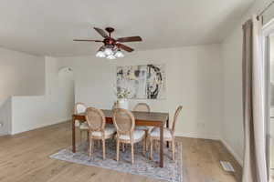 Dining space with ceiling fan and light hardwood / wood-style floors