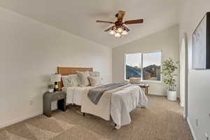 Carpeted bedroom with ceiling fan and vaulted ceiling