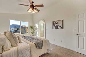 Bedroom featuring ceiling fan, lofted ceiling, and carpet flooring