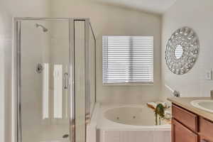 Bathroom featuring vanity and shower with separate bathtub