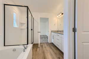 Bathroom featuring shower with separate bathtub, vanity, and hardwood / wood-style flooring