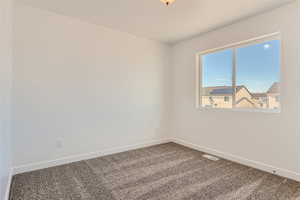 Carpeted empty room featuring a textured ceiling