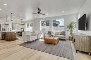 Living room with sink, ceiling fan, and light hardwood / wood-style flooring