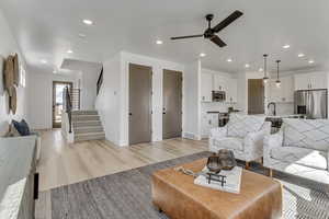 Living room featuring sink, ceiling fan, and light hardwood / wood-style flooring