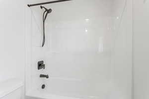 Bathroom with toilet and shower / bathing tub combination