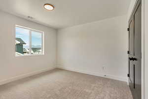 Unfurnished bedroom with light carpet, baseboards, and visible vents
