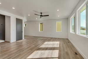 Unfurnished living room with baseboards, light wood-type flooring, recessed lighting, a ceiling fan, and visible vents