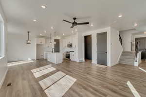 Unfurnished living room with baseboards, a ceiling fan, and visible vents