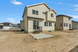 Rear view of property featuring entry steps and stucco siding
