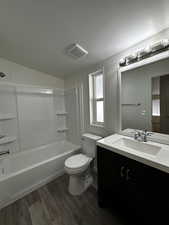 Full bathroom with shower / bathing tub combination, vanity, toilet, and hardwood / wood-style flooring