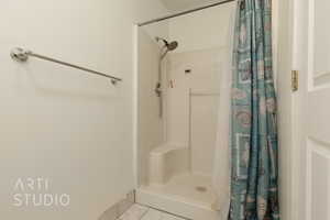 Bathroom with tile patterned flooring and a shower with curtain