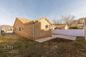 View of home's exterior featuring a yard, a mountain view, and a patio