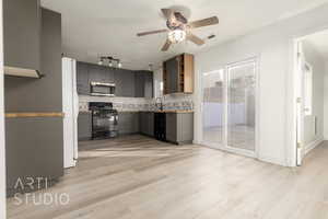 Kitchen featuring black appliances, tasteful backsplash, light wood-type flooring, gray cabinets, and ceiling fan