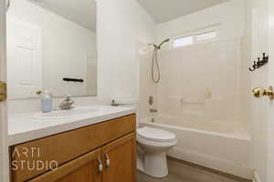 Full bathroom with toilet, bathing tub / shower combination, wood-type flooring, and vanity