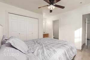 Bedroom featuring ensuite bathroom, a closet, ceiling fan, and light hardwood / wood-style floors