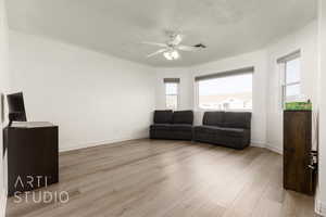 Living room featuring ceiling fan and light hardwood / wood-style floors