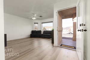 Living room featuring ceiling fan and light hardwood / wood-style floors