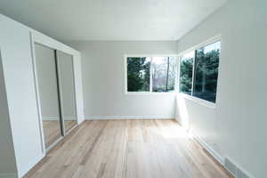 Unfurnished bedroom featuring light wood-type flooring and a closet