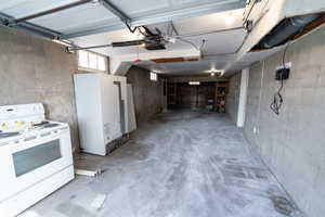 Garage featuring a garage door opener and fridge