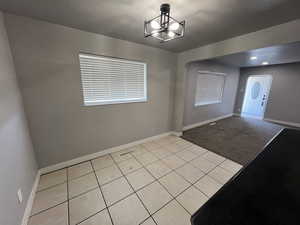 Carpeted foyer with an inviting chandelier