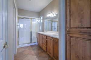 Bathroom featuring tile patterned flooring, an enclosed shower, and vanity