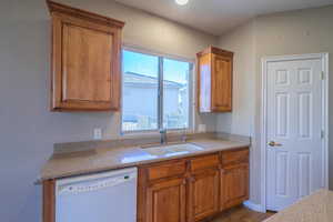 Kitchen featuring sink, light tile patterned floors, and dishwasher