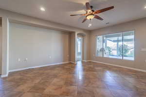 Living room with ceiling fan and area for entertainment center