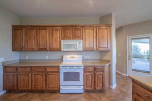 Kitchen featuring white appliances and light tile patterned floors