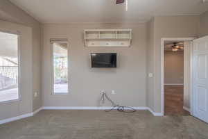 Unfurnished living room featuring ceiling fan and carpet