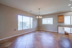 Large dining room & Kitchen featuring plenty of natural light, a notable chandelier, dishwasher, and hanging light fixtures