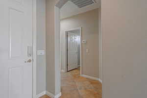 Hall to 2nd bed and bath with light tile patterned floors