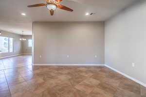 Living room with ceiling fan with notable chandelier