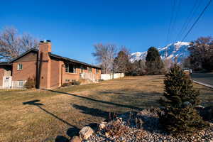 View of home's exterior featuring a lawn and a mountain view