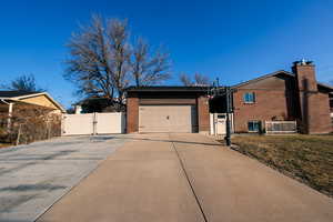 View of side of home with a garage and a lawn