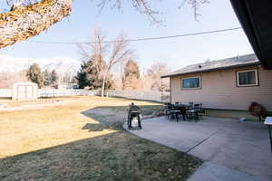 View of yard featuring a patio, a storage shed, and a mountain view