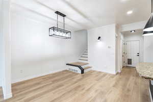 Unfurnished living room with light wood-type flooring and crown molding