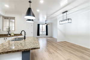 Kitchen featuring sink, decorative light fixtures, white cabinets, ornamental molding, and ceiling fan