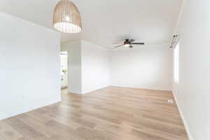 Unfurnished room featuring ornamental molding, ceiling fan, and light wood-type flooring